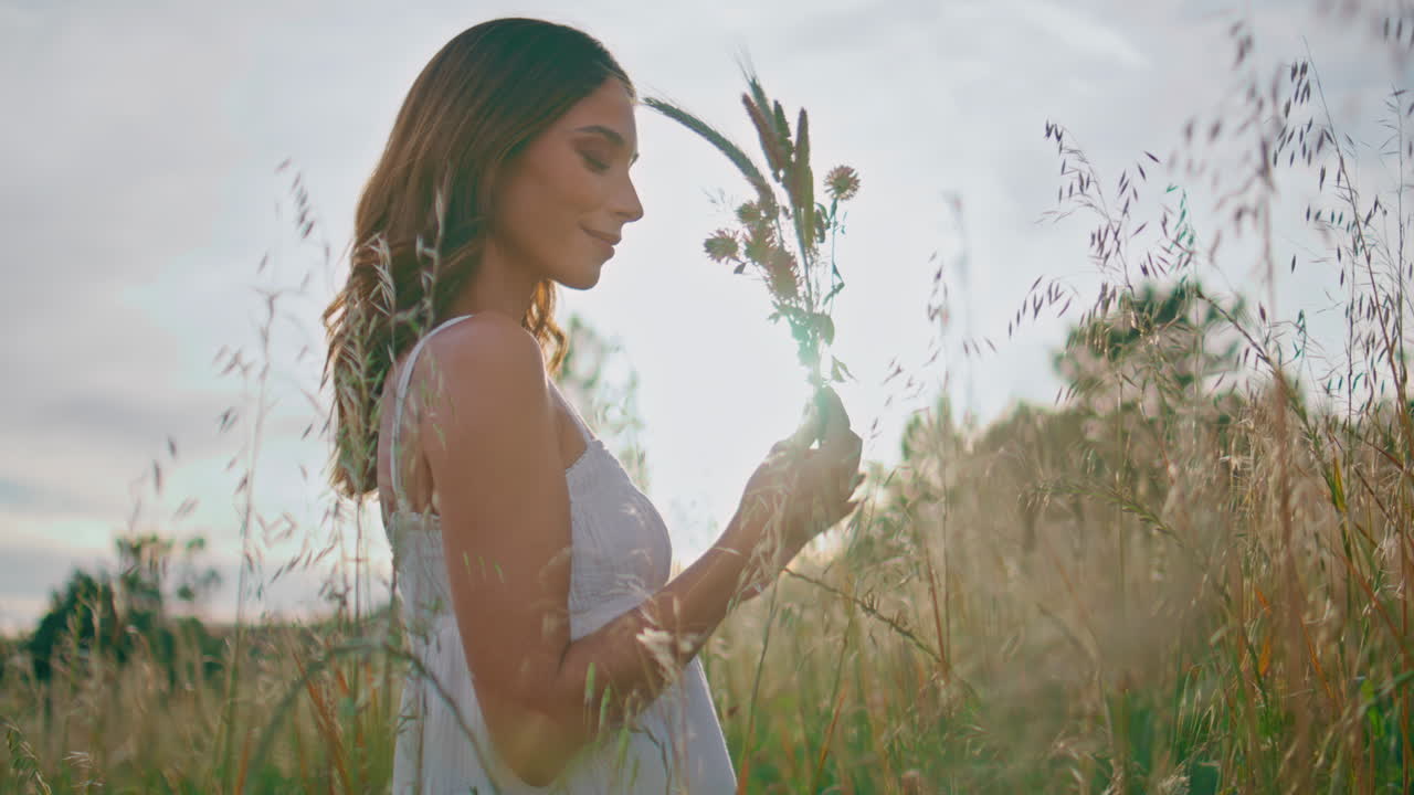 Gentle lady carrying bouquet spikelets at sunset closeup. Woman enjoying flowers