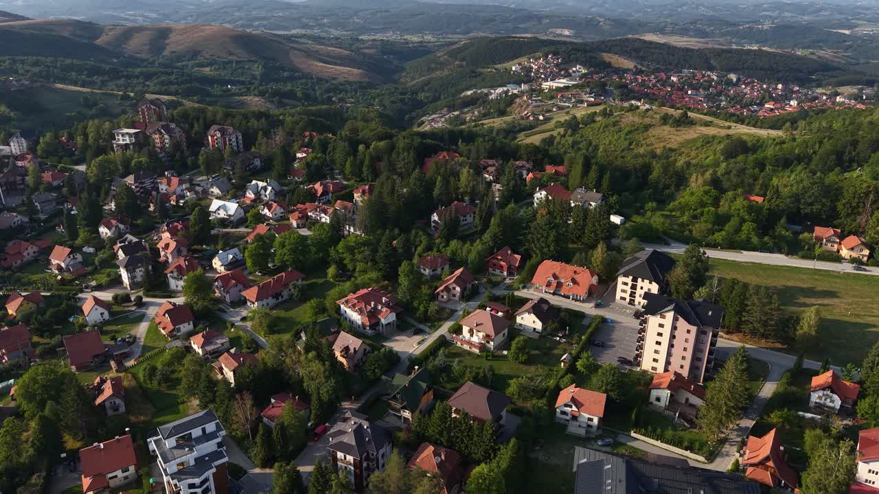 Drone Shot of Zlatibor Mountain Resort in Summer Season, Serbia. Apartment Buildings and Homes With Hills on Horizon