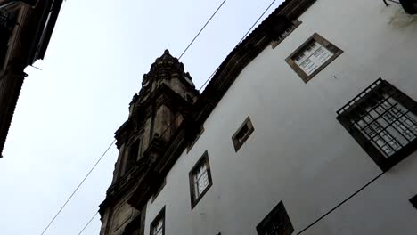 Niedrigwinkelumlaufbahn-Von-Torre-Dos-Clerigos-Aus-Einer-Gasse-In-Porto,-Portugal