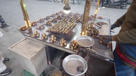 roasted chestnuts on a street vendor cart in a city