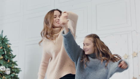 happy mom and daughter jumping up and down on bed in luxury house.