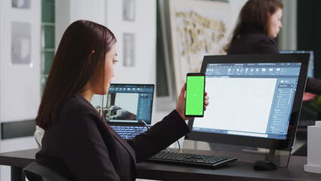 ingeniero mostrando teléfono con plantilla de pantalla verde en la pantalla