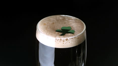 Shamrock-landing-on-head-of-pint-of-stout-on-black-background