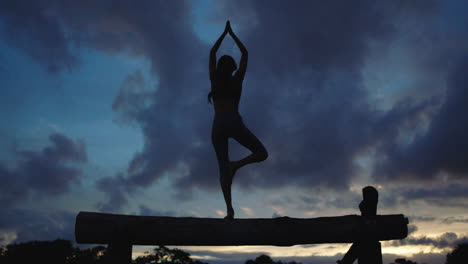 Silueta-De-Mujer-Joven-Pose-De-Yoga-Meditando-Equilibrio-Femenino-En-El-Fondo-Del-Crepúsculo-Vespertino
