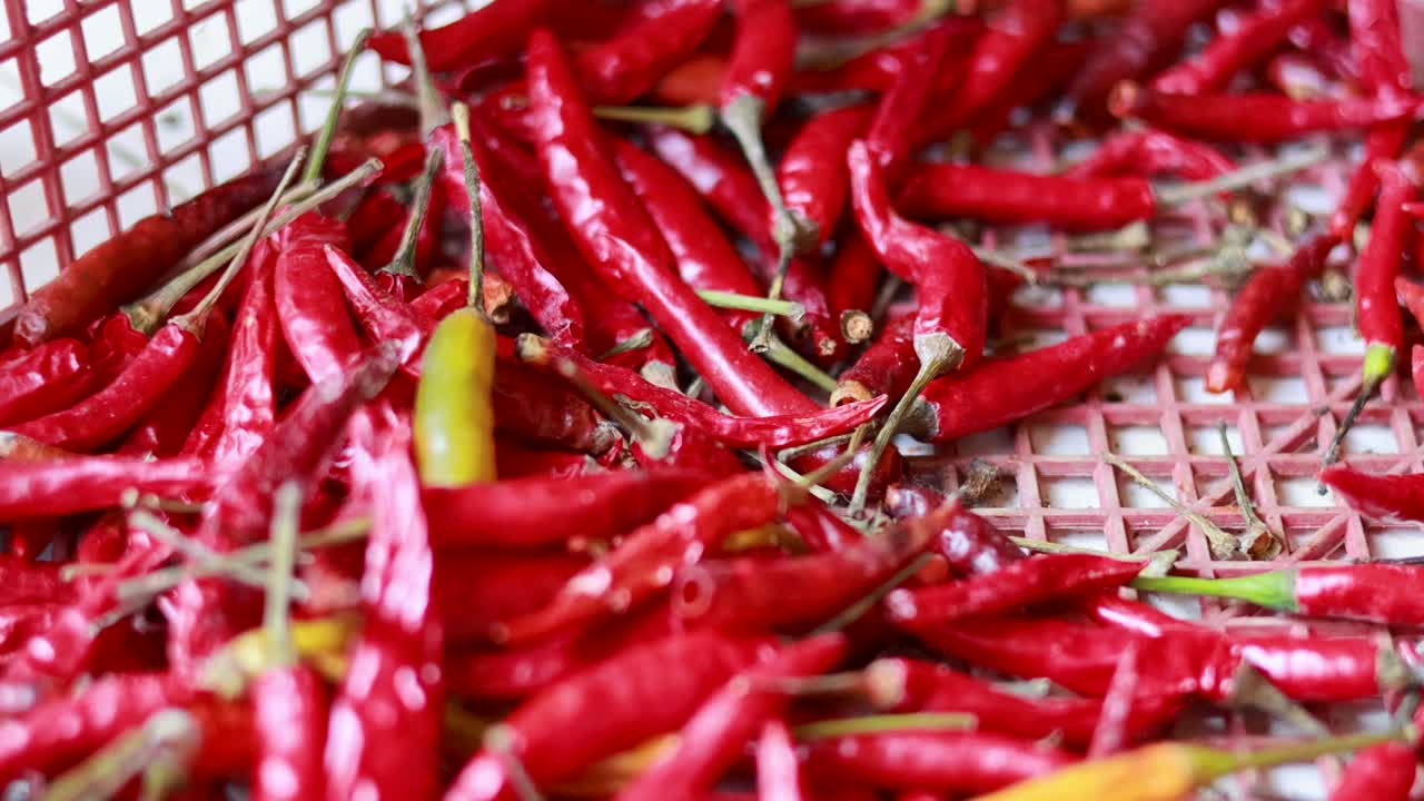 primer plano de chiles rojos y amarillos en una canasta con iluminación natural, mostrando colores y texturas vibrantes