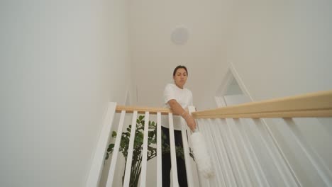 a beautiful pregnant woman tidying her home, engaged in household chores. the scene captures domestic life, maternity, and the balance of routine and preparation during pregnancy