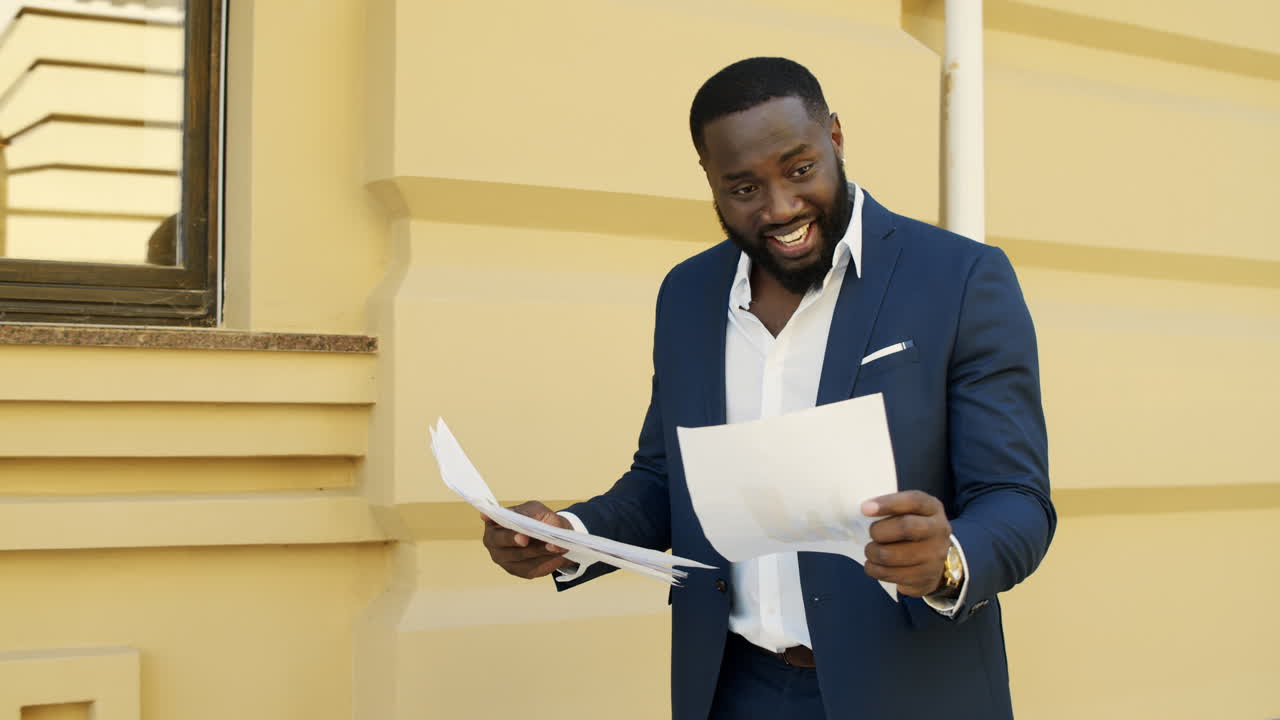 Cheerful african businessman checking documents outdoors