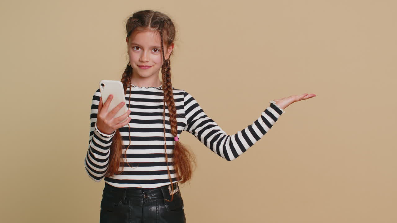 스마트폰을 가진 소녀 아이가 빈 장소를 가리키고 광고 영역을 복사하는 공간을 보여주고 있습니다.