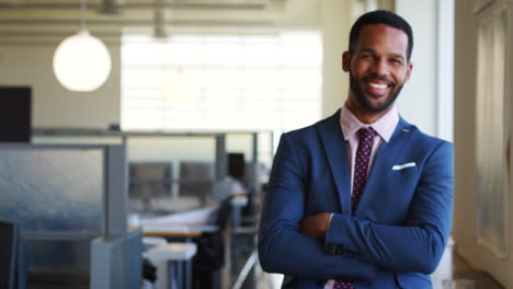 Young-black-businessman-walking-into-focus-in-office