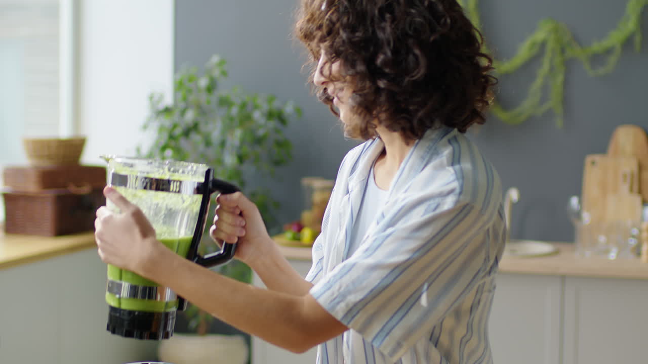 Ragazza che versa un frullato verde in un bicchiere