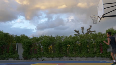 basketball player training alone at basketball court in vancouver, canada - dribbling, layup shot, bank shot - wide shot, side view