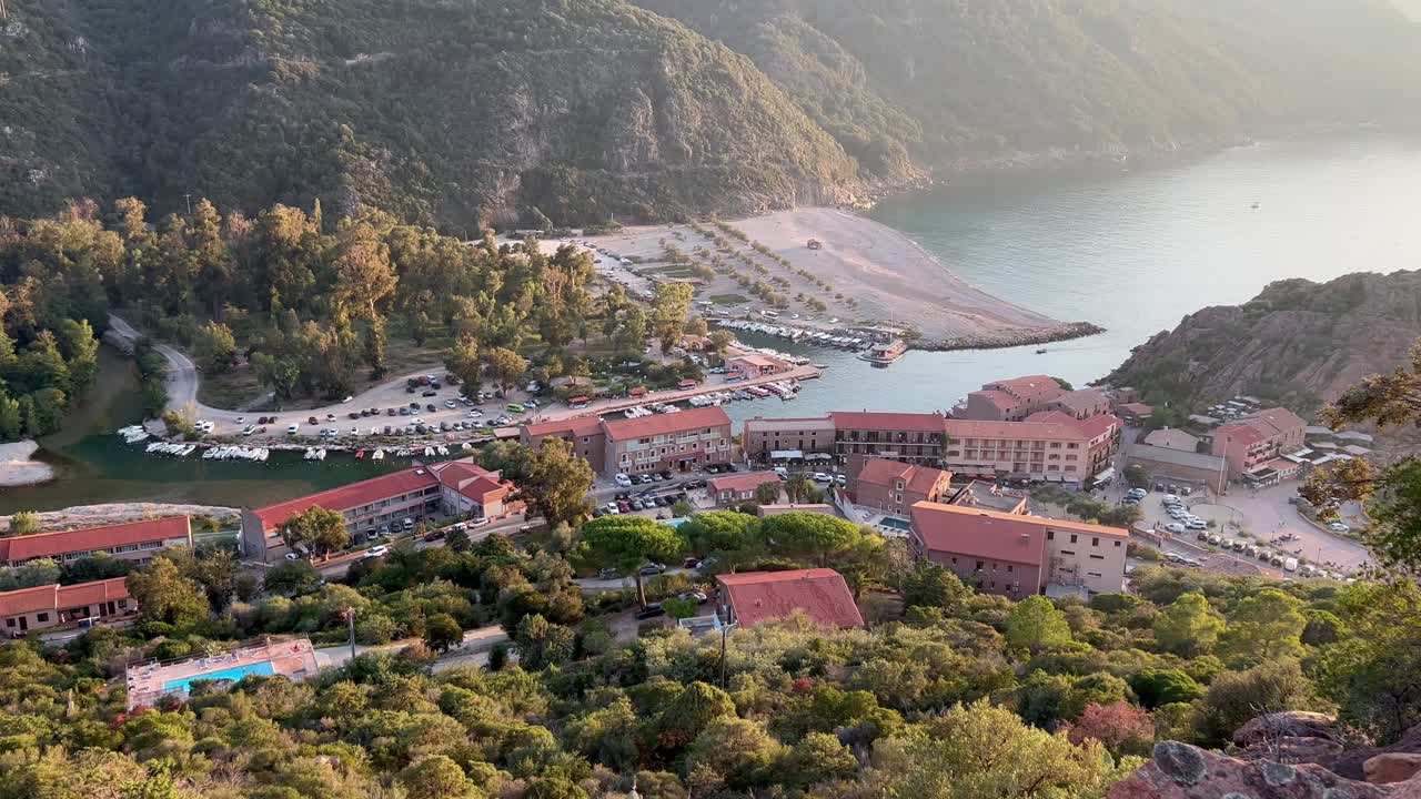 vista panorámica aérea de la ciudad de porto ota al atardecer con la torre de vigilancia genovesa en córcega, francia