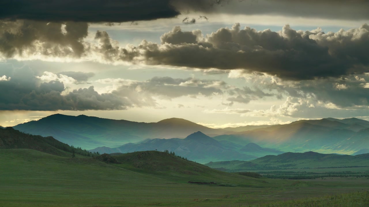 Dramatic Sunset Over Rolling Green Mountains and Stormy Clouds