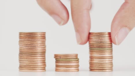 el dedo recoge una pequeña moneda de la pila.