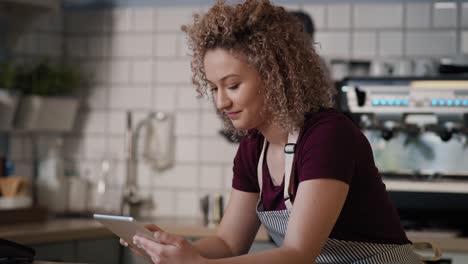 young caucasian waitress using digital tablet in the cafe.