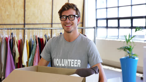 Volunteer-holding-clothes-donation-box-in-office