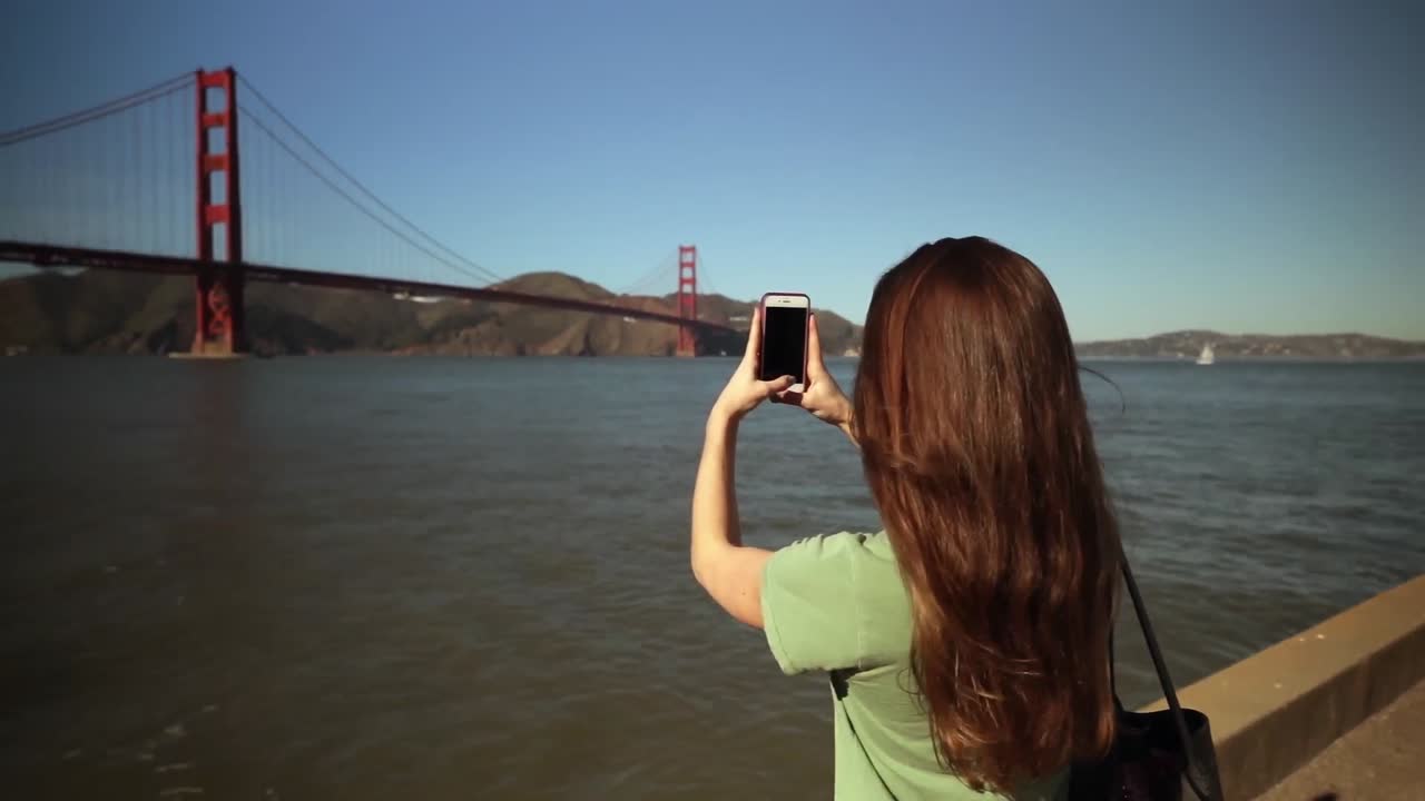 mujer fotografiando el puente golden gate, san francisco