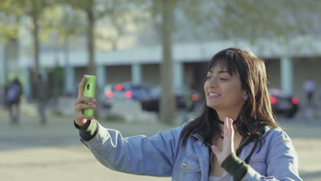 Happy-brunette-teenager-waving-and-talking-to-camera.