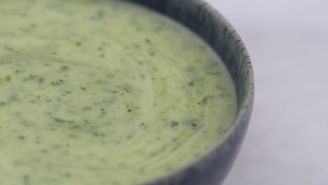 pan across a bowl of watercress soup. rotating blue bowl with white background. healthy lunchtime food.protein plant based raw vegan food. health and vegetarian foods. 4k macro food shot