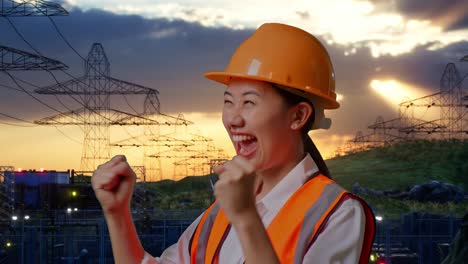 close up of side view of asian female engineer with safety helmet screaming goal celebrating working near high voltage tower