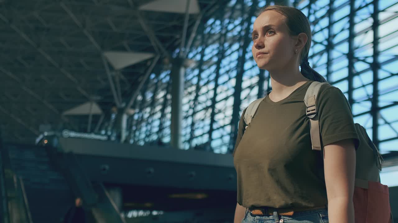 mujer viajera en el aeropuerto mirando el marcador de salidas buscando su vuelo