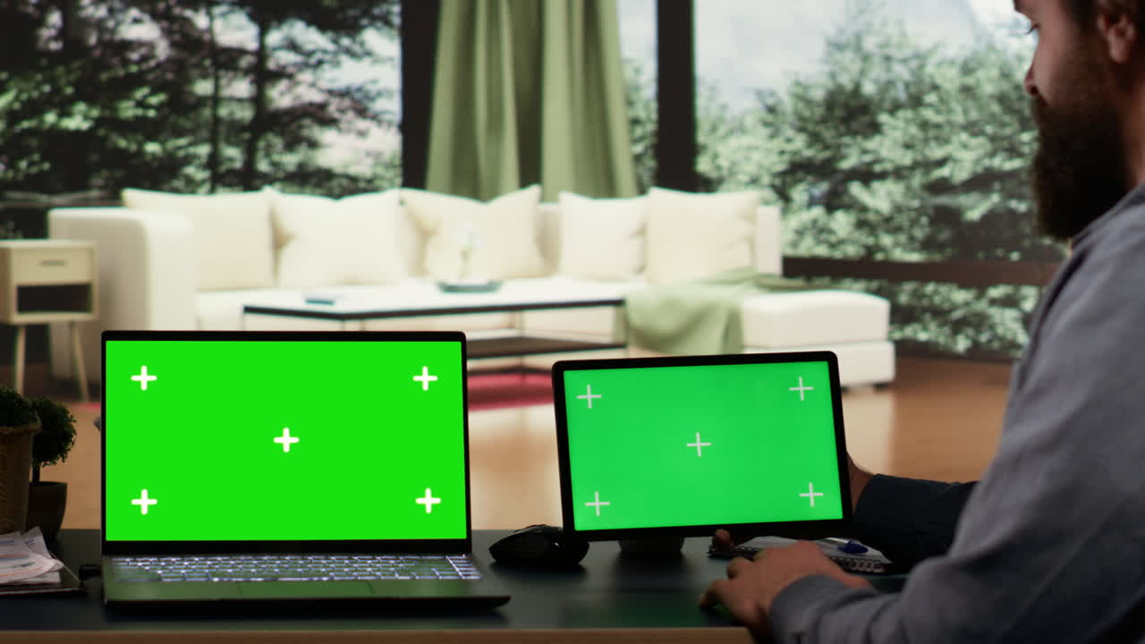 Entrepreneur works with greenscreen on laptop and tablet