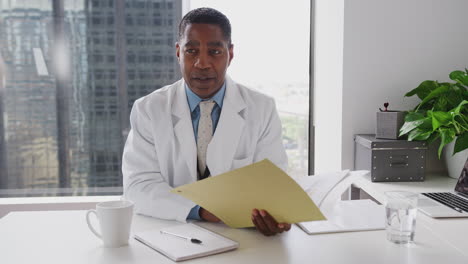male doctor with patient record meeting senior couple in office for consultation