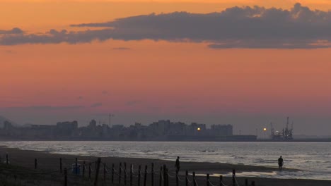 people walking on beach under evening sky, coastal seascape