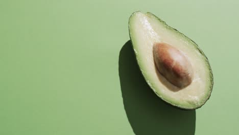 Video-of-sliced-avocado-with-copy-space-over-green-background