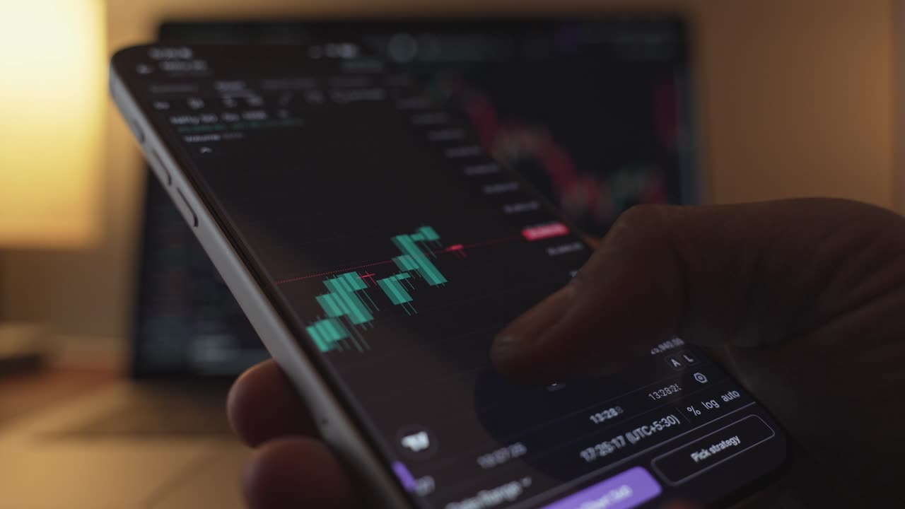 Stock Exchange Broker Analyzing Real-Time Stocks and Exchange Market Charts on Smartphone Using Online Trading App. Investment Agent Working in Office. Close Up