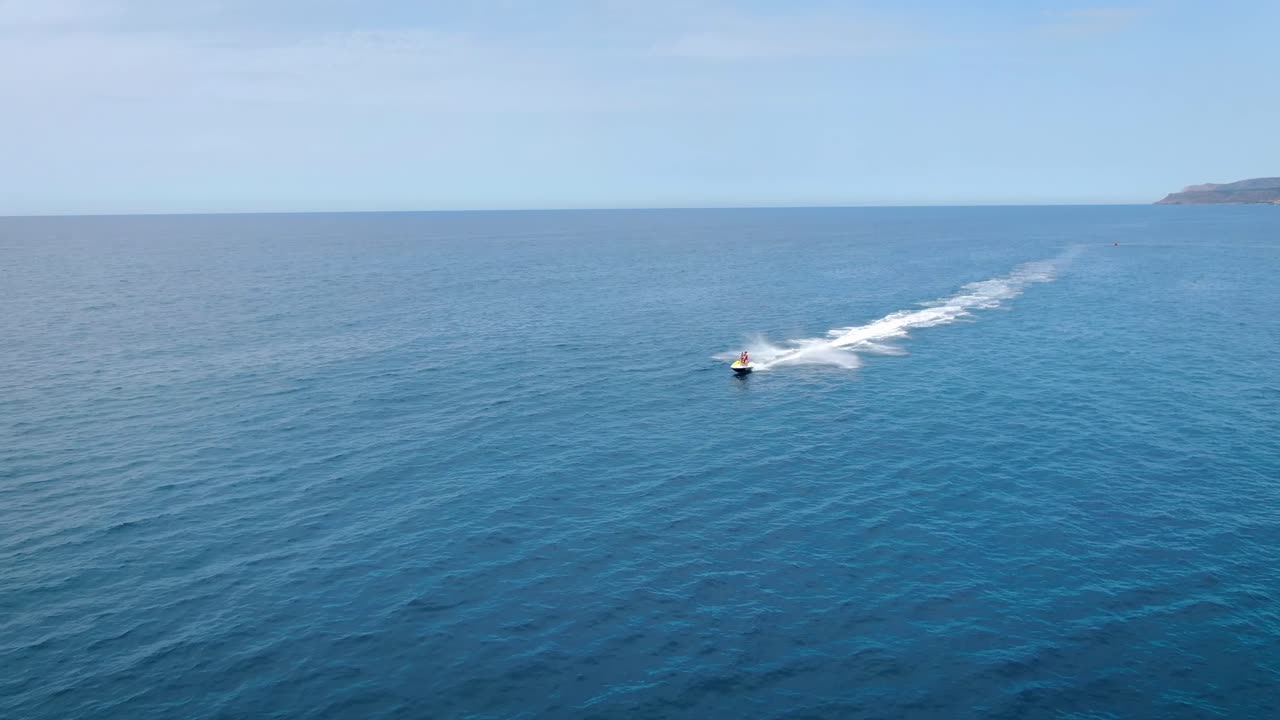 Aerial of a person doing jet ski in the Aegean Sea near Malia coast in Crete, Greece