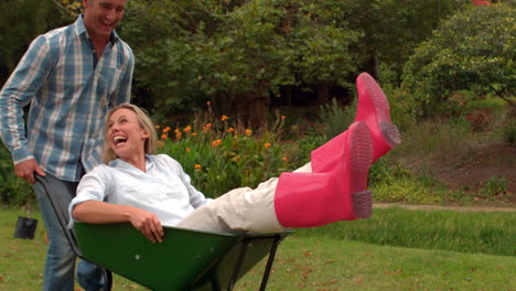 happy couple playing with a wheelbarrow