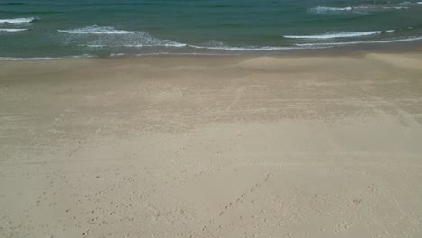 4k isolated top aerial view of a vacant beach with a few people - bat yam israel