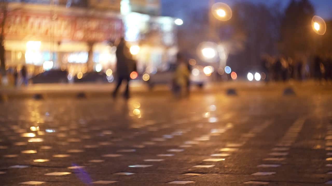 저녁 시내 거리와 사람들이 헤드라이트와 등불의 빛에 있는 영화적 보케