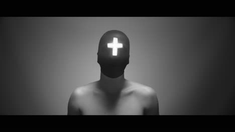 masked man with cross of light glowing on his face nods