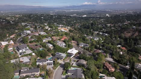 encino hills, california with suburban homes and lush greenery, mountain backdrop, aerial view