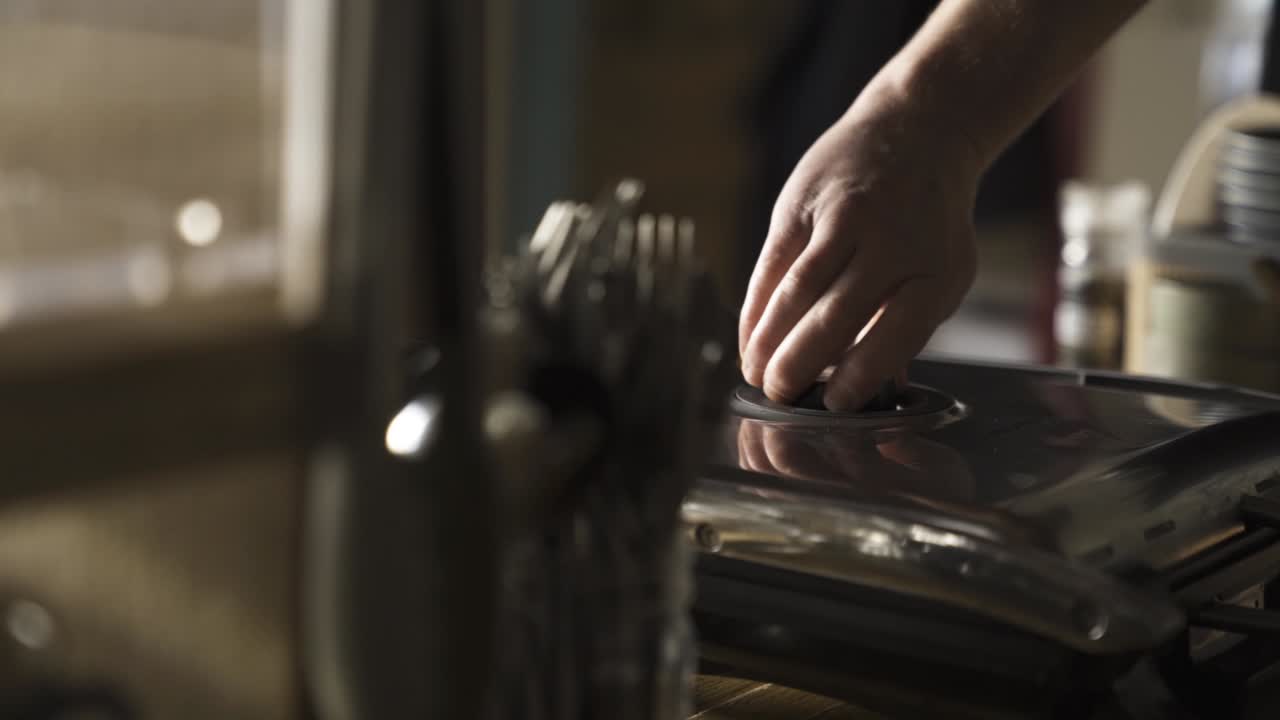 barista girando la máquina para hacer tostadas sándwich presione el botón de encendido o apagado girando el interruptor de temperatura macro disparo de mano