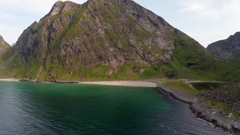 aerial shot of remote lofoten sandvika beach in noway surrounded by steep cliffs