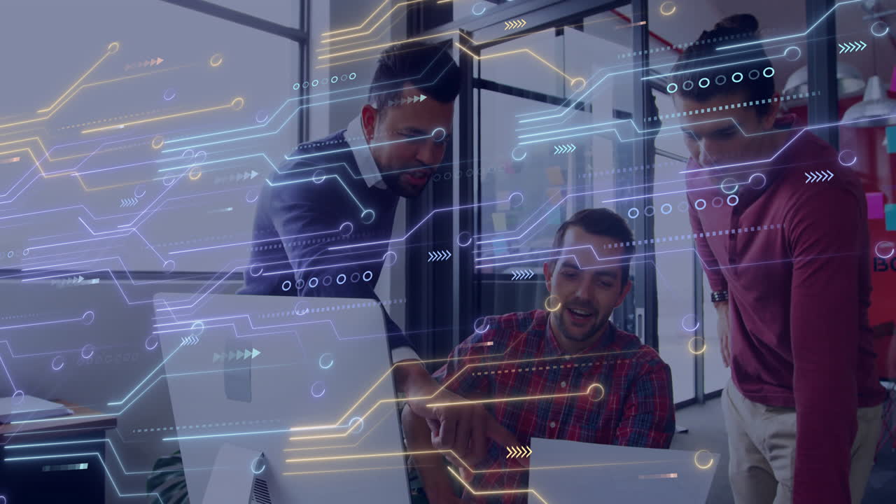 Men collaborating around desktop computer in technology office, showing data flow HUD graphics