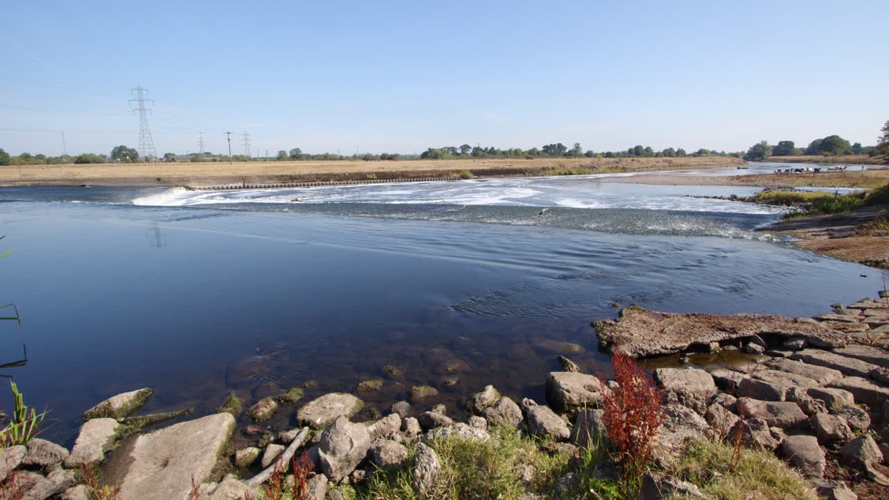 Water going over the River Trent weir with Rocky forground, by Ratcliffe on Soar Power station. Wide shot