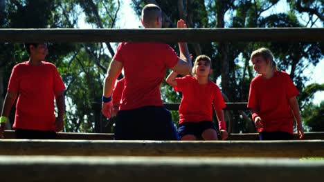 entrenador dando cinco altos a los niños en el campamento de entrenamiento