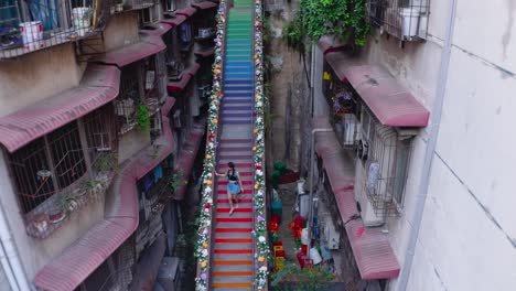 aerial view of a woman walking down the steep painted stairs in chongqing, china