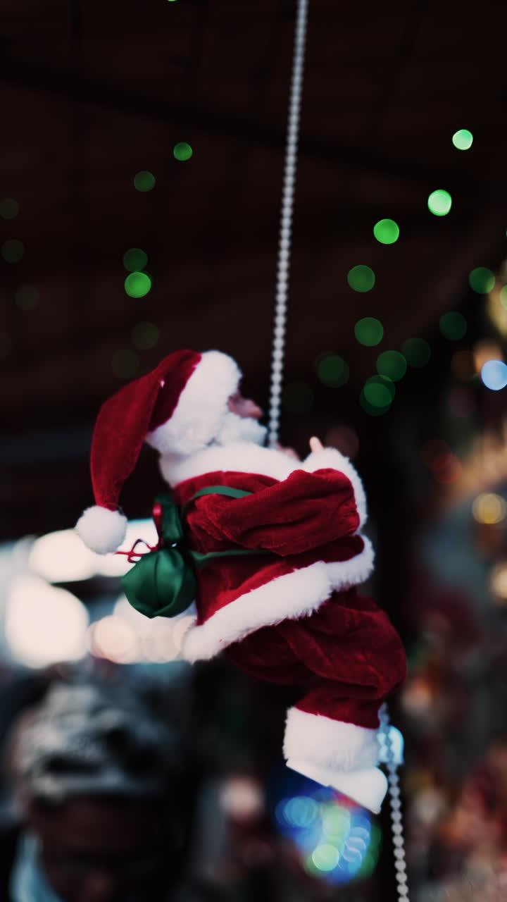 Santa Claus toy moving up and down a cord with a blurry background. Vertical