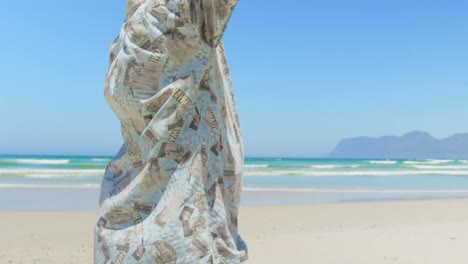 Side-view-of-active-senior-African-American-man-standing-with-arms-outstretched-on-the-beach-4k