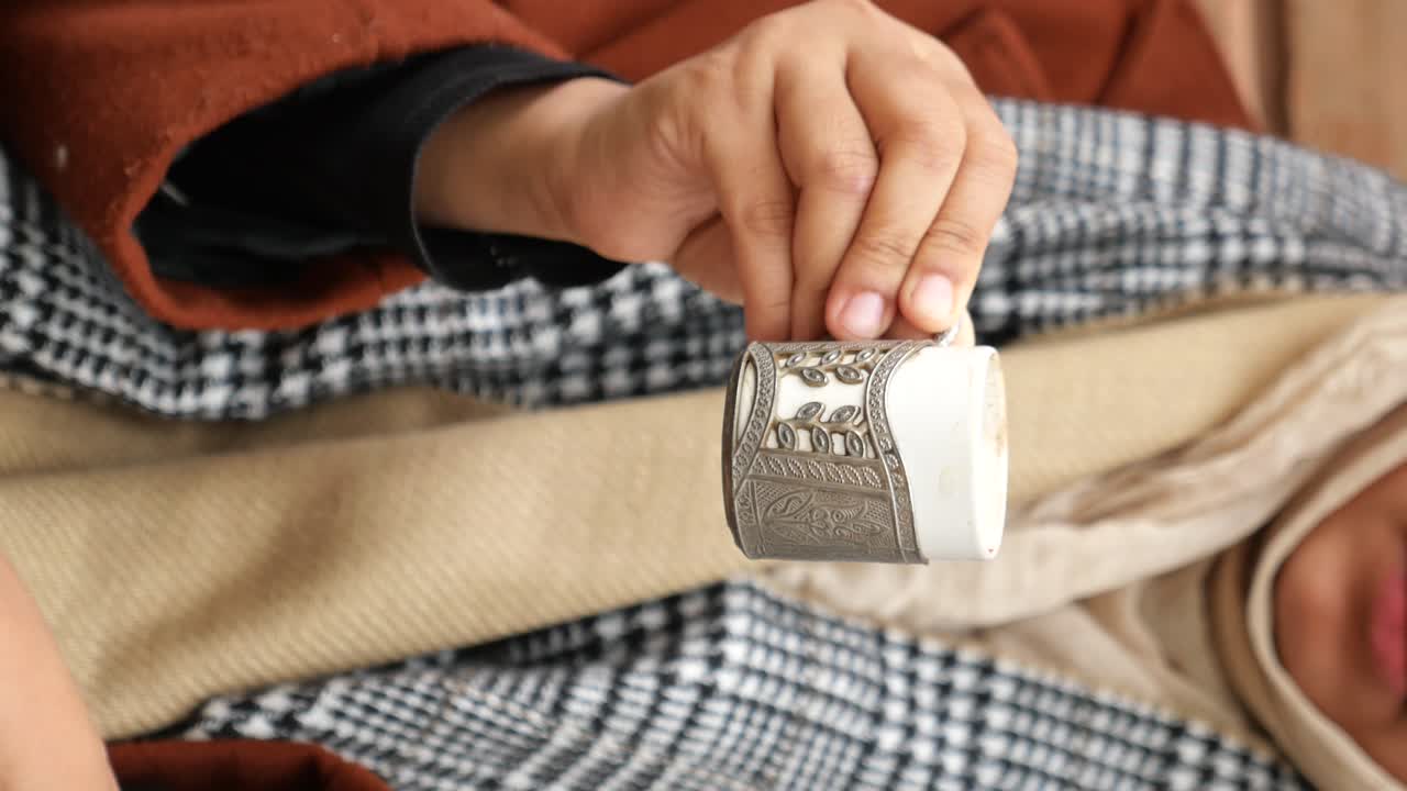 persona sosteniendo una taza de café decorada