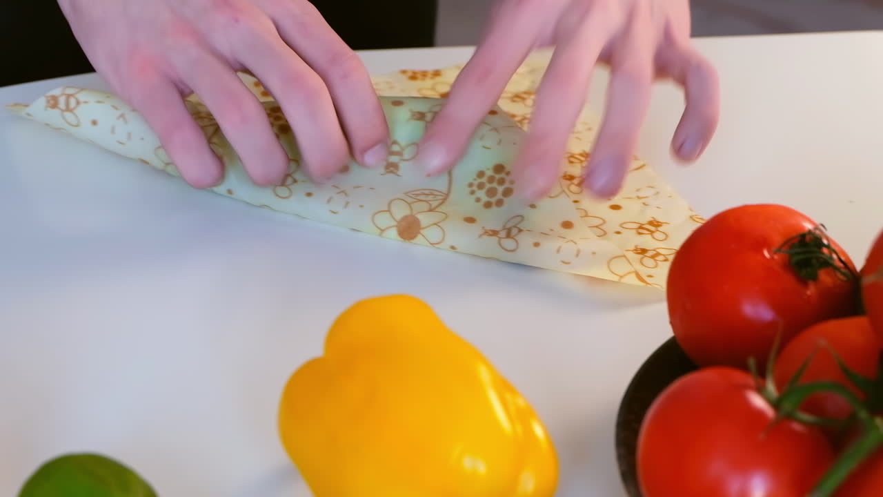 Man hands wrapping a fresh banana in beeswax food wrap