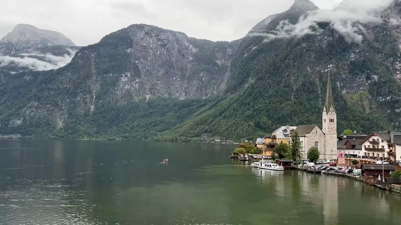 Smooth horizontal panning shot of the picturesque lakeside village of Hallstatt in Austria, with alpine scenery and serene water views