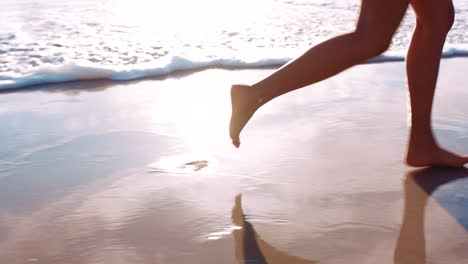 Woman-feet,-beach-sand-and-walking-in-water