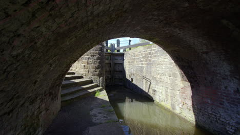 shot under the arch of a humpback bridge over the chesterfield canal at stret lock with lock in background