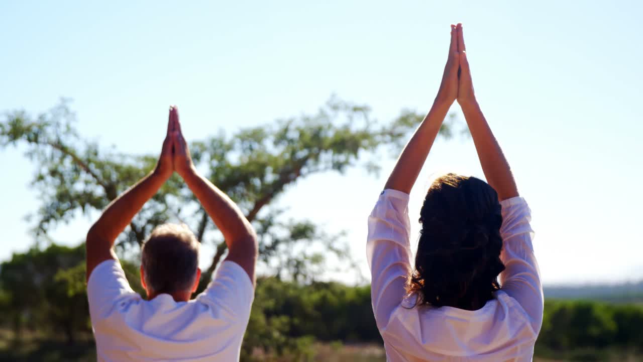 pareja haciendo yoga en un resort en un día soleado 4k